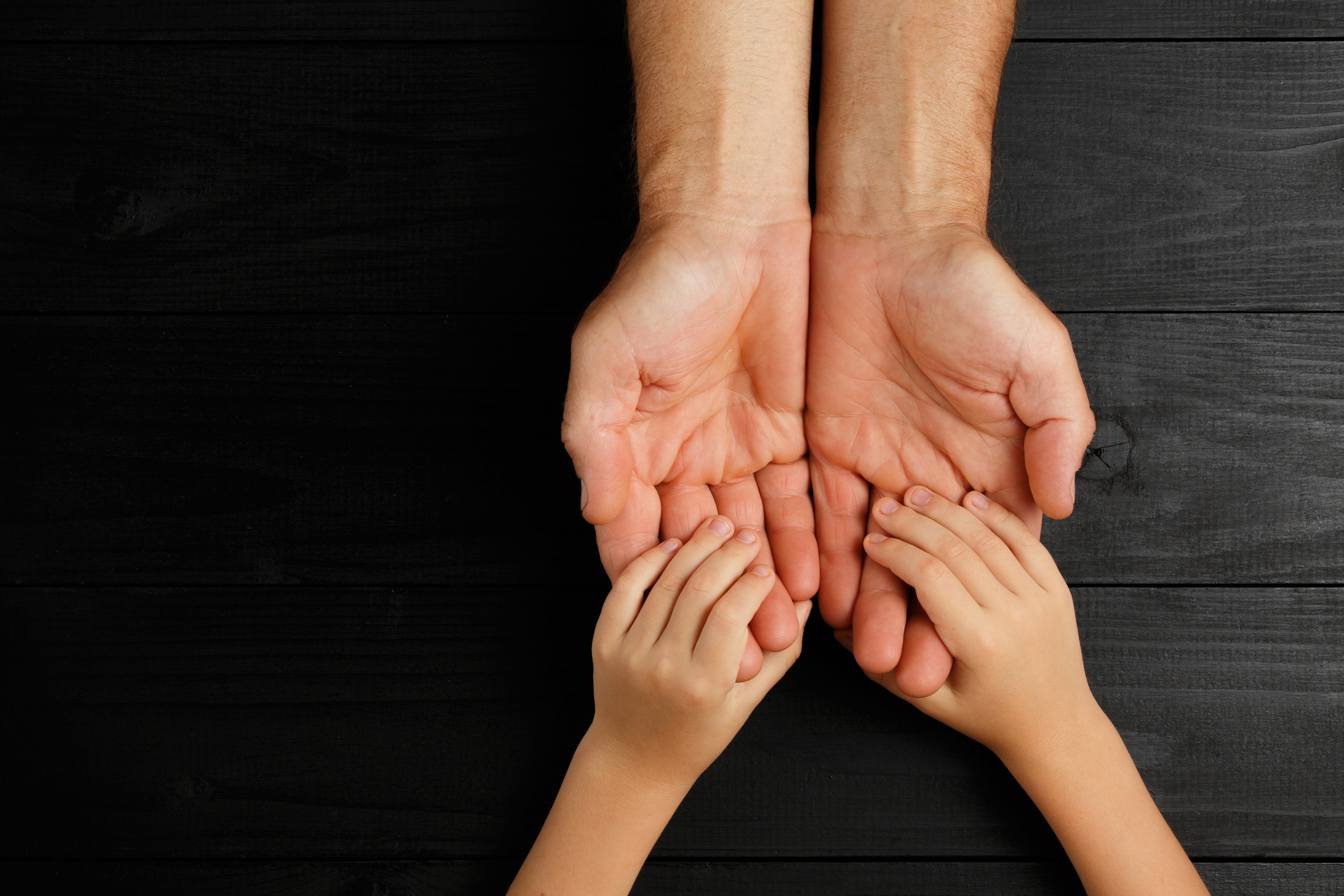 Adult hands holding kid hands, Family Help Care Concept